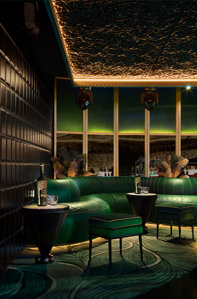 Emerald velvet lounge banquette with gold ceiling detail