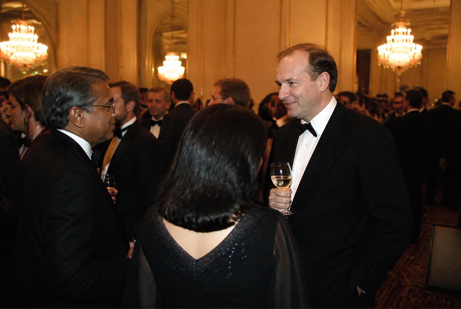 Executives networking beneath chandeliers at a corporate gala